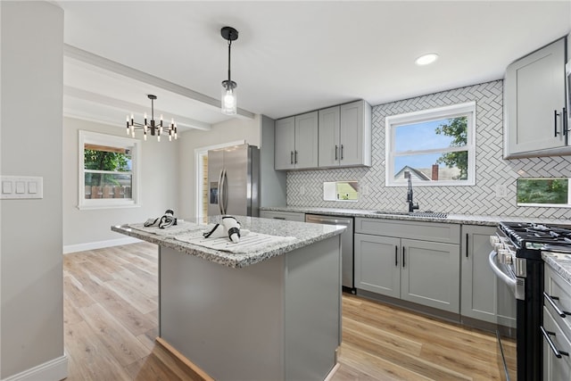 327 Charles Ave, New Kensington, PA 15068 - kitchen with appliances with stainless steel finishes, gray cabinetry, tasteful backsplash, light stone countertops, and beam ceiling