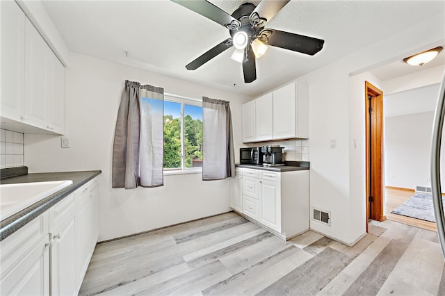 1541 Sugarloaf, Plum Boro, PA 15239 - kitchen with light wood-type flooring, dark countertops, tasteful backsplash, white cabinets, and a ceiling fan
