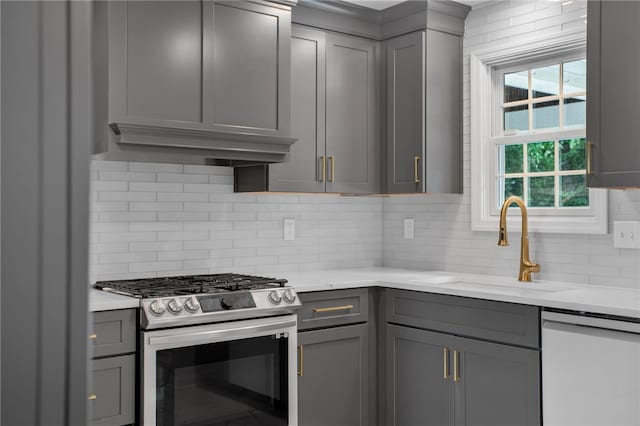 231 Loretta Dr, Monroeville, PA 15146 - kitchen with gas stove, gray cabinetry, dishwasher, tasteful backsplash, and light stone countertops