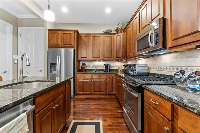 1 Riverfront St, Oakmont, PA 15139 - kitchen featuring appliances with stainless steel finishes, dark wood-style flooring, tasteful backsplash, dark stone counters, and ornamental molding