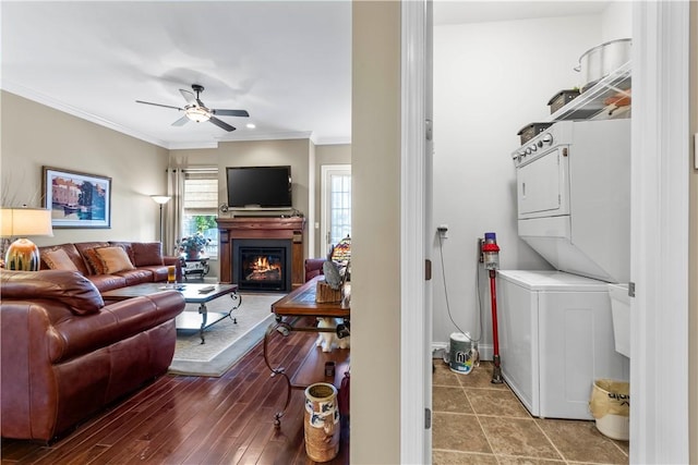 1 Riverfront St, Oakmont, PA 15139 - laundry area featuring stacked washer / dryer, ornamental molding, ceiling fan, and a warm lit fireplace
