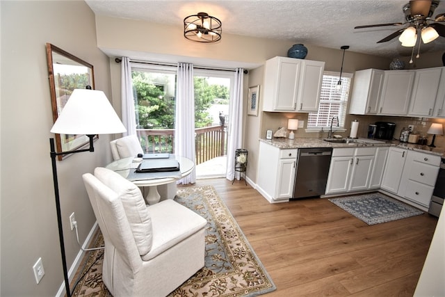 121 Sedeca Dr, North Strabane, PA 15317 - kitchen with stainless steel dishwasher, light wood-style flooring, white cabinetry, ceiling fan, and light stone counters