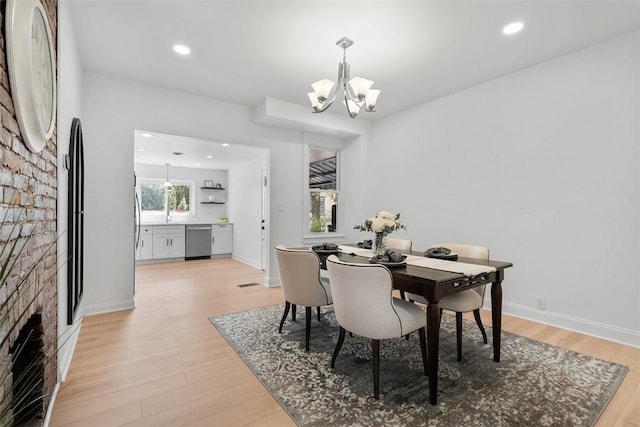 5110 Duncan St, Lawrenceville, PA 15201 - dining area with a chandelier, light wood finished floors, a fireplace, and recessed lighting