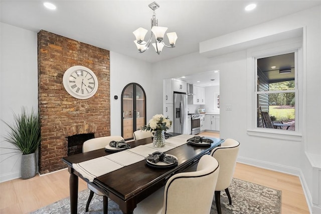 5110 Duncan St, Lawrenceville, PA 15201 - dining room featuring a chandelier, light wood-style flooring, recessed lighting, and a brick fireplace