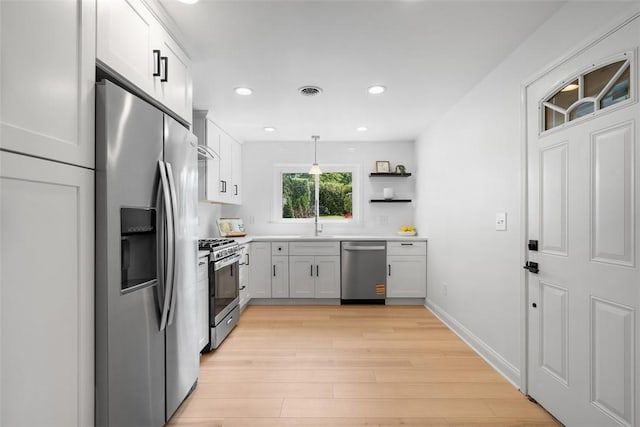 5110 Duncan St, Lawrenceville, PA 15201 - kitchen featuring appliances with stainless steel finishes, light wood-style flooring, pendant lighting, light countertops, and open shelves
