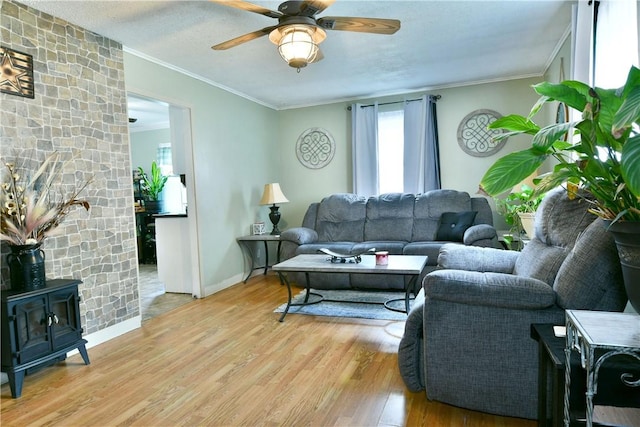114 10th St, Pymatuning Twp, PA 16125 - living room featuring healthy amount of natural light, light wood-style floors, a wood stove, crown molding, and a ceiling fan