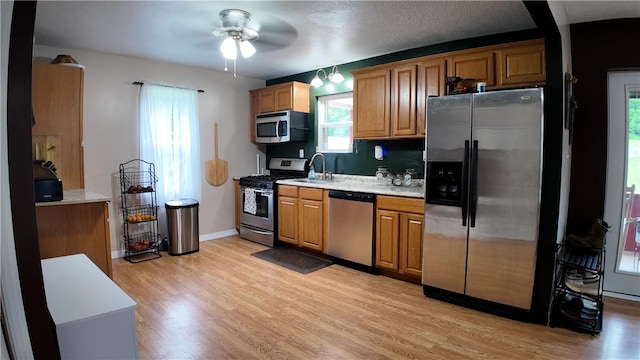 180 Beale Rd, Buffalo Twp, PA 16055 - kitchen with appliances with stainless steel finishes, a ceiling fan, light wood-style floors, light countertops, and brown cabinets