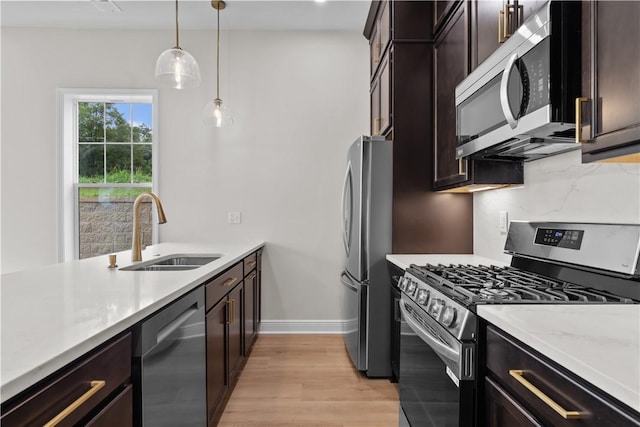 2215 Lebanon Dr, Elizabeth Twp/Boro, PA 15135 - kitchen featuring stainless steel appliances, light wood-style floors, light countertops, pendant lighting, and dark brown cabinetry