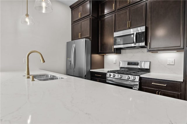 2215 Lebanon Dr, Elizabeth Twp/Boro, PA 15135 - kitchen featuring stainless steel appliances, hanging light fixtures, dark brown cabinetry, light stone countertops, and decorative backsplash
