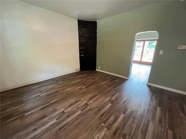 702 Sellers Ave, Jeannette, PA 15644 - empty room featuring dark wood-type flooring and arched walkways