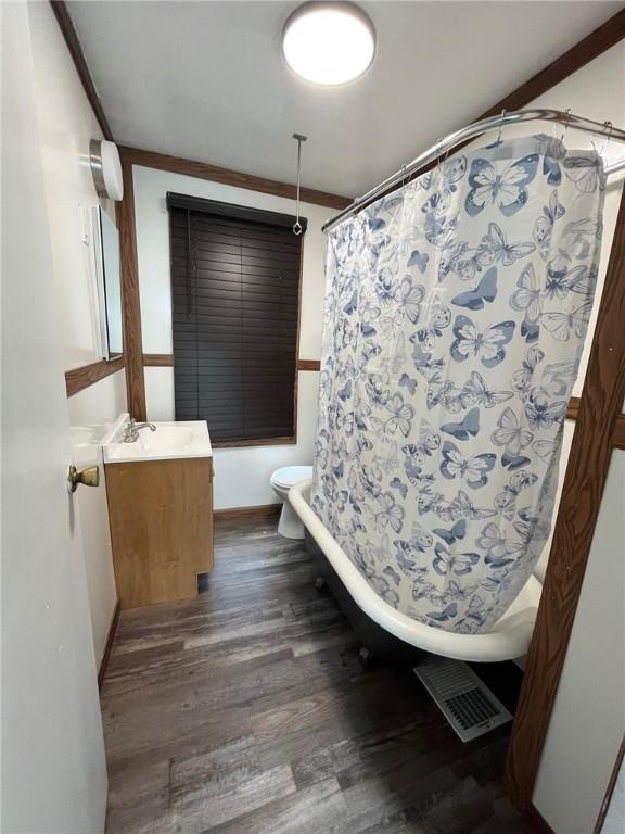 702 Sellers Ave, Jeannette, PA 15644 - bathroom featuring wood finished floors, vanity, and shower / bath combo with shower curtain