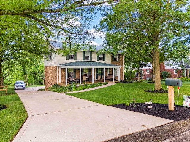 44 Stonehenge Dr, South Strabane, PA 15301 - view of front of home with a porch, brick siding, driveway, a front yard, and roof with shingles