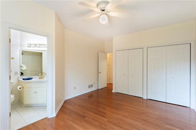 103 Boxwood Ct, Peters Twp, PA 15317 - unfurnished bedroom with two closets, light wood-type flooring, connected bathroom, and ceiling fan
