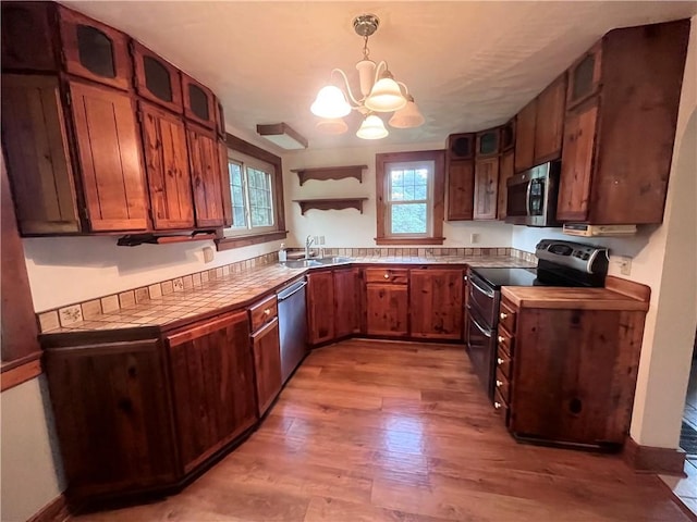 423 Bonniebrook Rd, Summit Twp, PA 16002 - kitchen featuring appliances with stainless steel finishes, a chandelier, light wood-type flooring, and glass insert cabinets