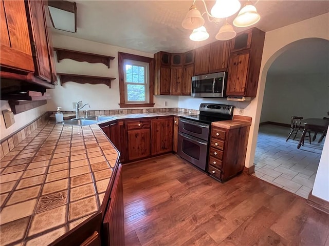 423 Bonniebrook Rd, Summit Twp, PA 16002 - kitchen with appliances with stainless steel finishes, arched walkways, a chandelier, open shelves, and tile counters