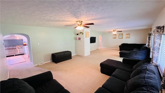 324 Paul Dr, Lower Burrell, PA 15068 - living area featuring a ceiling fan, arched walkways, carpet floors, and a textured ceiling