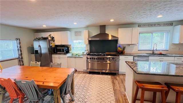 324 Paul Dr, Lower Burrell, PA 15068 - kitchen with appliances with stainless steel finishes, wall chimney range hood, white cabinets, a textured ceiling, and dark stone counters