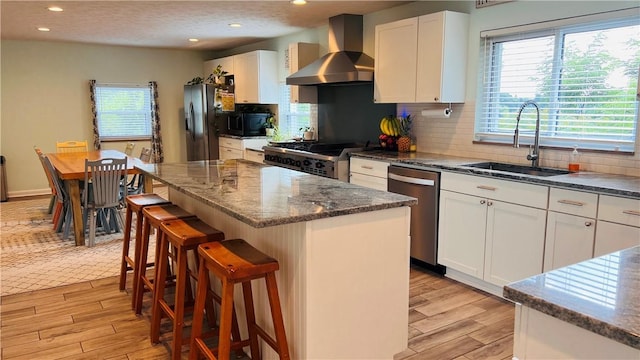 324 Paul Dr, Lower Burrell, PA 15068 - kitchen with wall chimney range hood, appliances with stainless steel finishes, light wood finished floors, plenty of natural light, and recessed lighting
