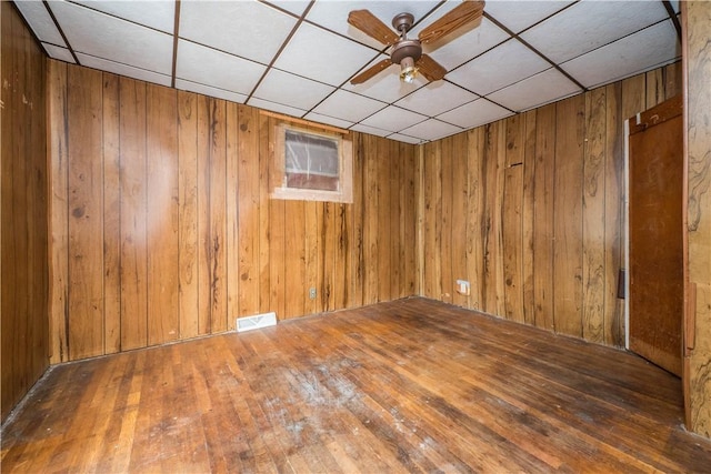 1115 Fairdale St, Sheraden, PA 15204 - unfurnished room with wood walls, a paneled ceiling, a ceiling fan, and hardwood / wood-style flooring