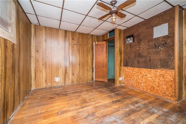 1115 Fairdale St, Sheraden, PA 15204 - spare room with a ceiling fan, wooden walls, hardwood / wood-style floors, and a paneled ceiling