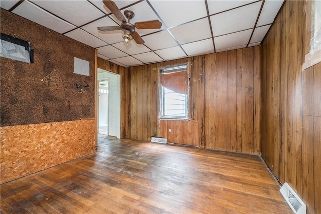 1115 Fairdale St, Sheraden, PA 15204 - empty room featuring hardwood / wood-style floors, a paneled ceiling, wooden walls, and a ceiling fan
