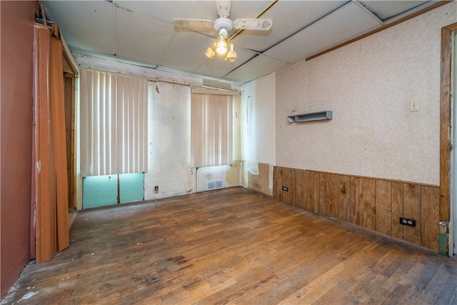 1115 Fairdale St, Sheraden, PA 15204 - spare room featuring wood-type flooring, a ceiling fan, a wainscoted wall, and wood walls