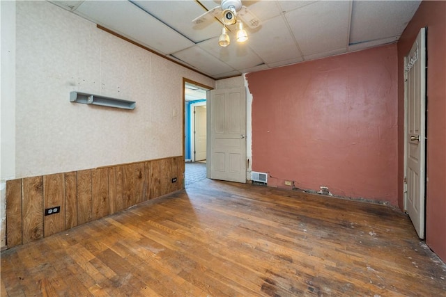 1115 Fairdale St, Sheraden, PA 15204 - empty room featuring a ceiling fan, hardwood / wood-style floors, a wainscoted wall, a drop ceiling, and wood walls