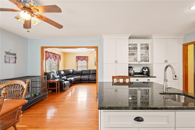 604 Lake Shore Rd, Lake Stonycreek, PA 15541 - kitchen with a ceiling fan, light wood-type flooring, white cabinetry, glass insert cabinets, and dark stone counters