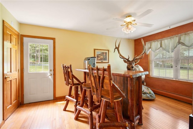 604 Lake Shore Rd, Lake Stonycreek, PA 15541 - dining area featuring light wood finished floors, a baseboard radiator, a dry bar, and ceiling fan