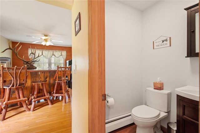 604 Lake Shore Rd, Lake Stonycreek, PA 15541 - half bathroom featuring a baseboard heating unit, wood finished floors, vanity, and ceiling fan