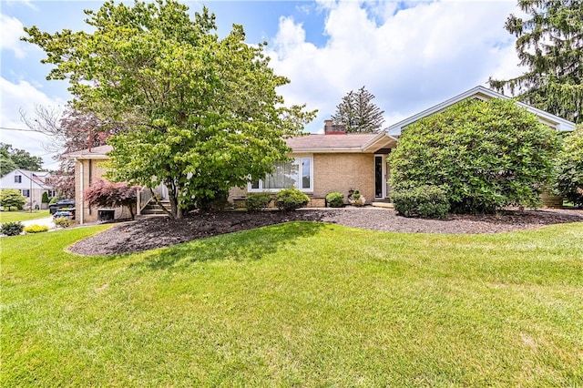 127 Mount Odin Dr, Hempfield Twp, PA 15601 - view of front facade featuring brick siding, a front lawn, and a chimney