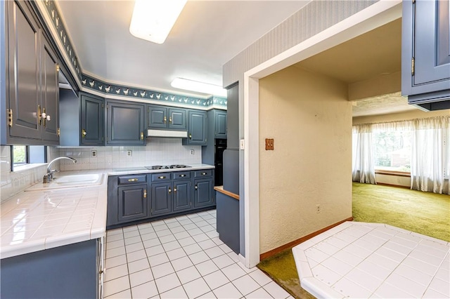 127 Mount Odin Dr, Hempfield Twp, PA 15601 - kitchen featuring tile counters, blue cabinetry, light tile patterned floors, and under cabinet range hood