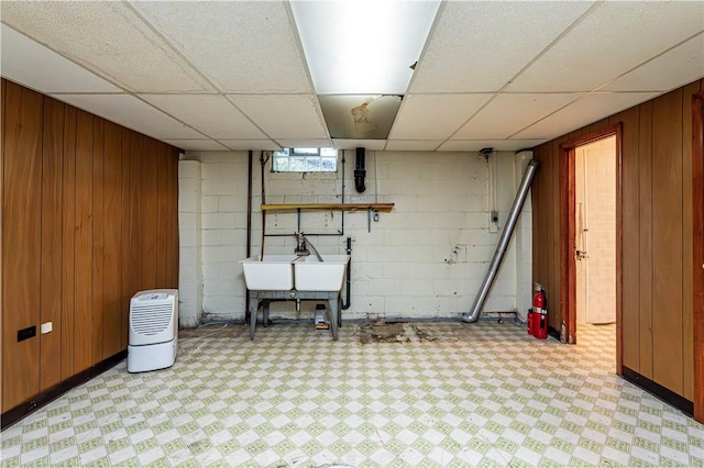127 Mount Odin Dr, Hempfield Twp, PA 15601 - basement featuring light flooring, wooden walls, a paneled ceiling, and concrete block wall