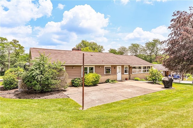 127 Mount Odin Dr, Hempfield Twp, PA 15601 - back of house featuring a yard, a patio, brick siding, and a chimney