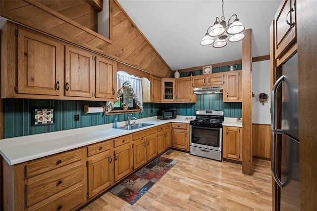 71 Mcclure Rd, West Deer, PA 15024 - kitchen with stainless steel gas range oven, freestanding refrigerator, under cabinet range hood, brown cabinets, and lofted ceiling