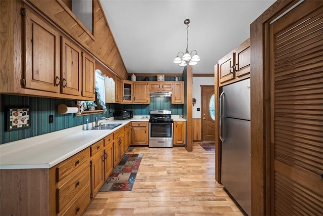 71 Mcclure Rd, West Deer, PA 15024 - kitchen with stainless steel appliances, light wood-style floors, a chandelier, light countertops, and under cabinet range hood