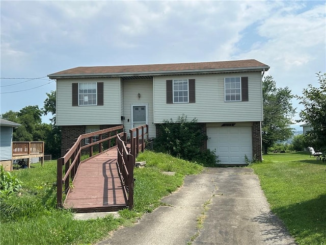 201 N 10th St, Connellsville, PA 15425 - raised ranch featuring brick siding, a garage, asphalt driveway, and a front lawn