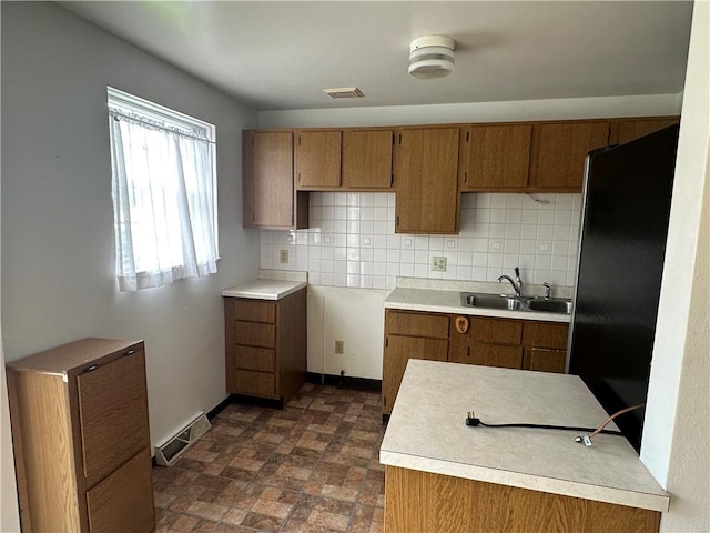 201 N 10th St, Connellsville, PA 15425 - kitchen with brown cabinetry, freestanding refrigerator, and tasteful backsplash
