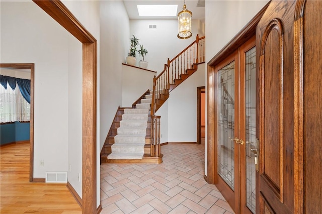 4 Hawthorne Ln, Penn Twp, PA 15642 - foyer entrance with stairway, a chandelier, french doors, a skylight, and light wood finished floors