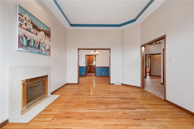 4 Hawthorne Ln, Penn Twp, PA 15642 - unfurnished living room featuring a chandelier, light wood-style flooring, a high end fireplace, and a high ceiling