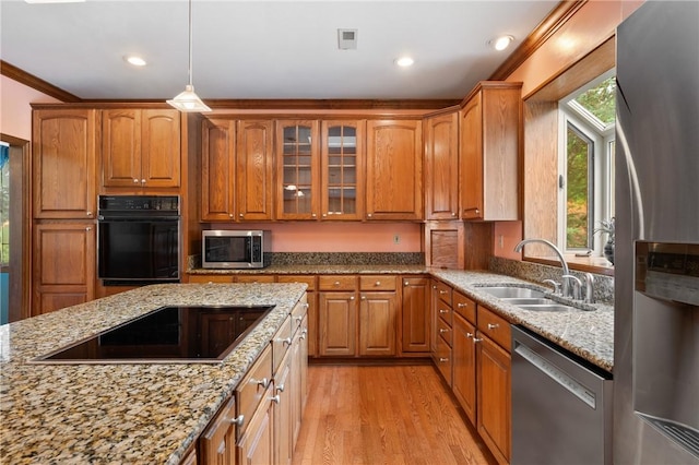 4 Hawthorne Ln, Penn Twp, PA 15642 - kitchen featuring black appliances, light stone countertops, light wood-style floors, glass insert cabinets, and brown cabinets