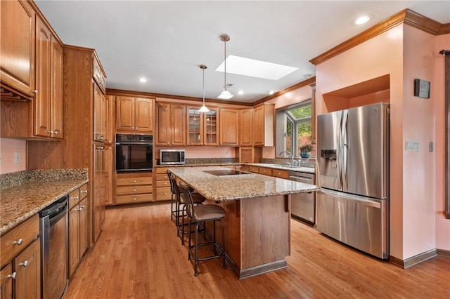 4 Hawthorne Ln, Penn Twp, PA 15642 - kitchen featuring black appliances, crown molding, brown cabinetry, a breakfast bar, and a skylight