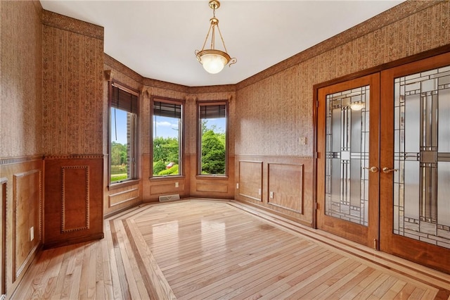 4 Hawthorne Ln, Penn Twp, PA 15642 - spare room featuring wallpapered walls, french doors, light wood-style flooring, a wainscoted wall, and a decorative wall