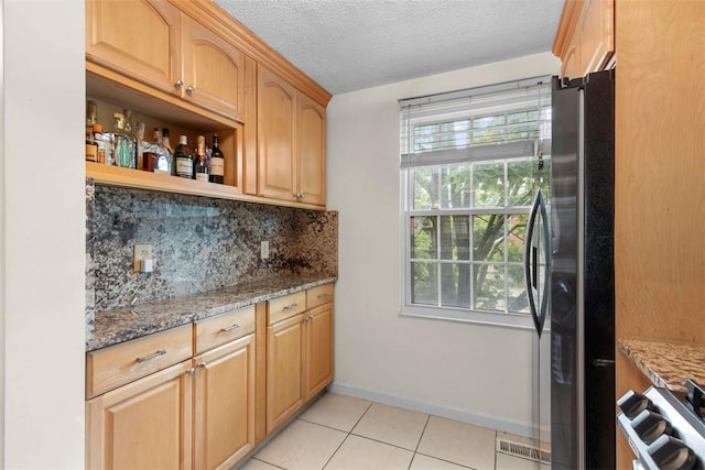 3269 Dawson St, Oakland, PA 15213 - kitchen with freestanding refrigerator, light stone countertops, tasteful backsplash, light tile patterned flooring, and a textured ceiling