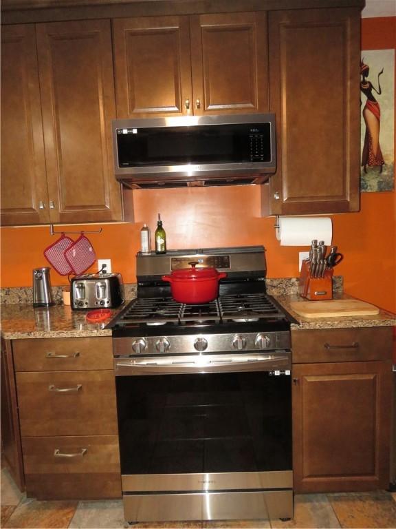 103 Cedar St, Masontown, PA 15461 - kitchen with appliances with stainless steel finishes, brown cabinetry, and light stone countertops