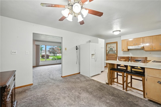 215 Diane Dr, Carroll Twp, PA 15063 - kitchen featuring white fridge with ice dispenser, under cabinet range hood, light carpet, ceiling fan, and light countertops