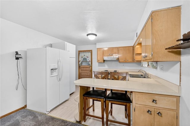 215 Diane Dr, Carroll Twp, PA 15063 - kitchen with white refrigerator with ice dispenser, under cabinet range hood, light countertops, a peninsula, and stainless steel cooktop
