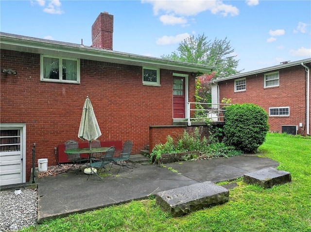 215 Diane Dr, Carroll Twp, PA 15063 - rear view of property with brick siding, a chimney, a patio area, and a lawn