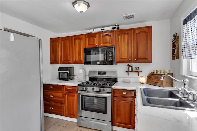 2128 Stoops Ct, Apollo Boro, PA 15673 - kitchen featuring stainless steel appliances, brown cabinets, and light stone countertops
