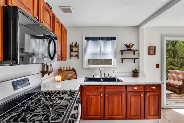 2128 Stoops Ct, Apollo Boro, PA 15673 - kitchen featuring stainless steel gas range oven, black microwave, light stone countertops, and light tile patterned flooring